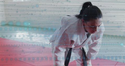 Female judo black belt leaning forward practicing drill on dojo mats with digital glitch overlay