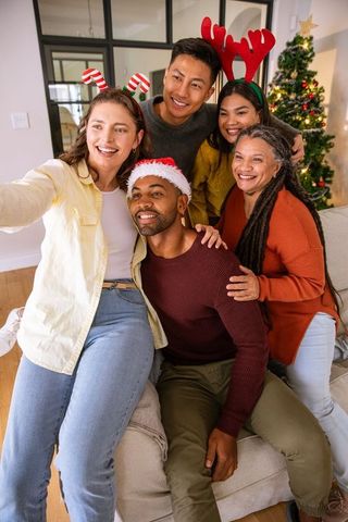 Diverse Friends Taking Festive Selfie by Christmas Tree