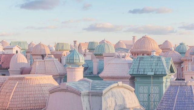 Pastel rooftop cityscape with domes turrets and ornate cupolas in soft morning light view