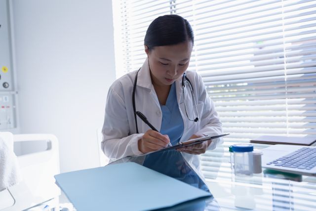 Doctor in a professional setting filling out a medical prescription. Useful for depicting healthcare, patient treatment, and clinical processes. Ideal for medical blogs, healthcare websites, and educational materials.
