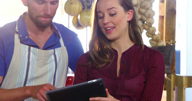 Man and Woman Collaborating in Market with Tablet - Download Free Stock Images Pikwizard.com