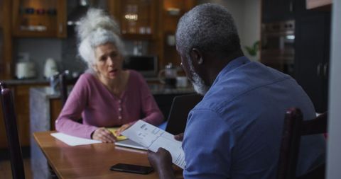 Senior Couple Managing Finances Together in Kitchen