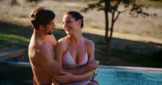 A young Caucasian couple enjoys a romantic moment together in a hot tub, with copy space. Their smiles and affectionate embrace convey a sense of happiness and intimacy.