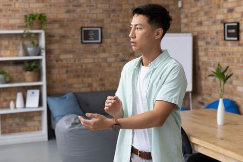 Asian professional collaborating in modern office with brick wall