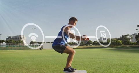 Male athlete squatting on plyo box holding medicine ball with digital fitness overlay