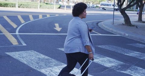 Confident Woman Walking with Luggage in Urban Street