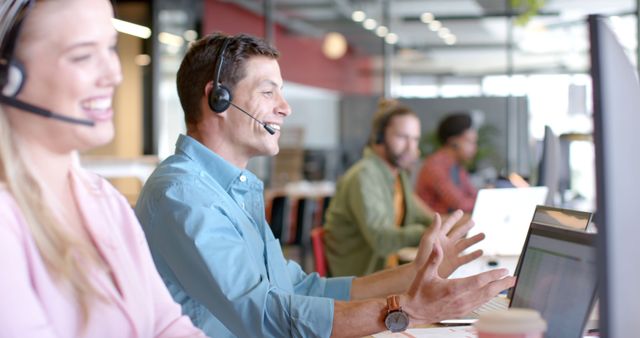 Employees engaged in customer support activities, equipped with headsets and working on laptops. Modern and professional office environment. Suitable for showcasing customer service teams, teamwork and communications in business settings.