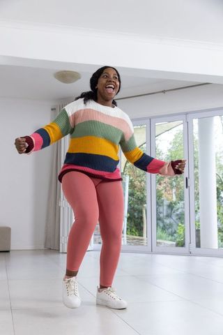 Energetic woman jumping indoors for joyful exercise