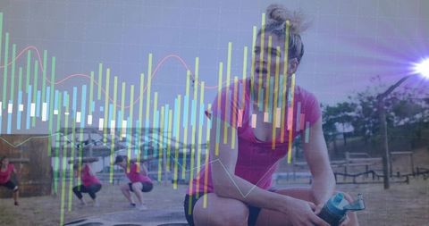 Female athlete resting during outdoor group workout with fitness analytics overlay
