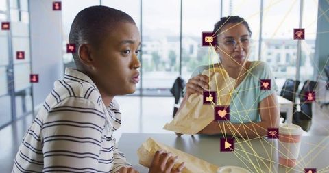 Coworkers Eating Lunch and Chatting in Modern Office with Digital Network and Social Icons