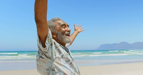 Senior Man Enjoying Beach with Open Arms on Sunny Day