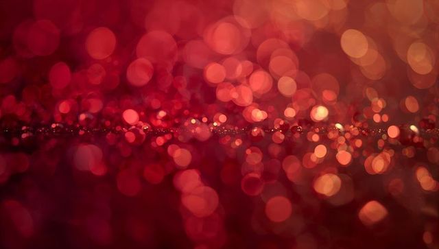 Shimmering crimson glitter bokeh with warm gold sparkle and shallow depth