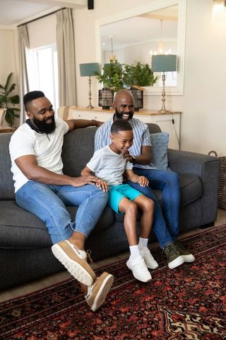 Smiling Family Relaxing on Comfortable Sofa at Home
