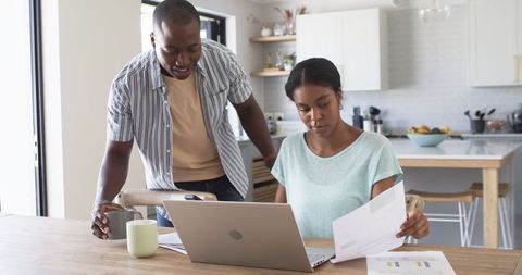 Couple Managing Finances Together at Home with Laptop