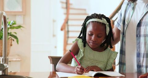 African American Family Journaling on Sunny Day at Home