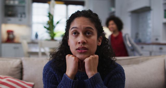 Woman Reflecting on Couch at Home with Companion in Background - Download Free Stock Images Pikwizard.com