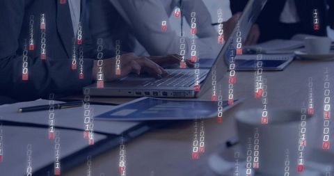 Executive team typing on laptop with binary code overlay for cybersecurity data analysis
