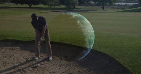 Golfer lining up bunker shot with holographic earth overlay on golf green for futuristic training