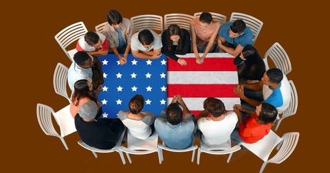 Diverse group collaborating around us flag table