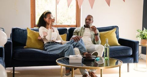 Couple Celebrating with Wine at Home on Comfortable Sofa