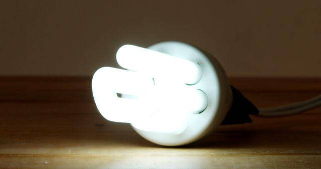 Glowing Energy-Saving LED Light Bulb on Wooden Surface - Download Free Stock Images Pikwizard.com