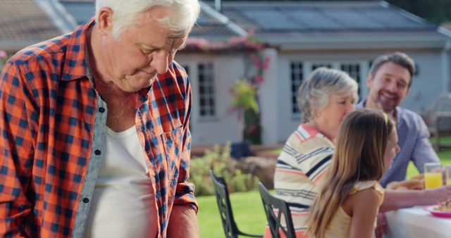 Grandfather Enjoying Family Barbecue Outdoors - Download Free Stock Images Pikwizard.com