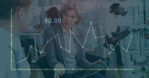 Mature executive analyzing data with graph overlay in modern office