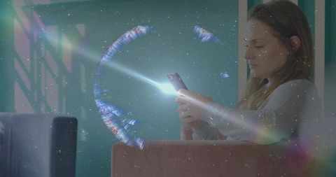 Woman using smartphone with holographic ring projection glowing in modern living room