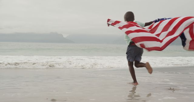 Happy Child Running on Beach with American Flag on Overcast Day - Download Free Stock Images Pikwizard.com