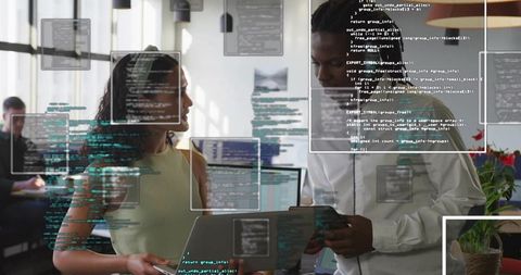 Colleagues Reviewing Code on Laptop and Tablet in Modern Office