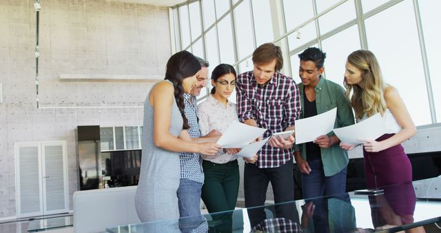 Diverse Business Team Collaborating on Documents in Modern Office - Download Free Stock Images Pikwizard.com