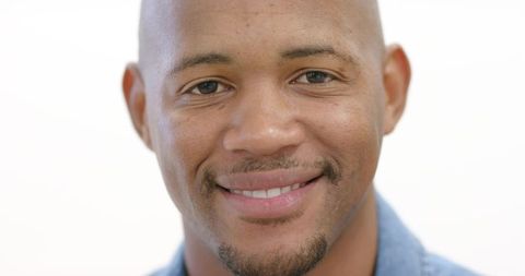 Confident african american man smiling in denim shirt closeup portrait on white background