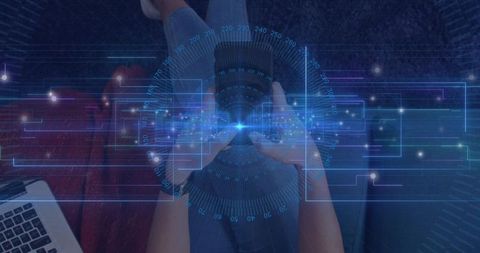 Holding smartphone with holographic ar interface over laptop on sofa, tapping for mobile tech