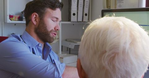 Doctor Discussing Treatment with Elderly Patient during COVID-19