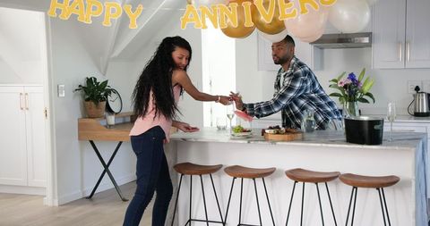 Couple Cleaning After Anniversary Celebration in Cozy Kitchen