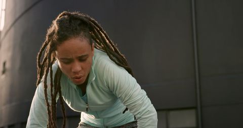 Exhausted Woman with Dreadlocks Resting After Intense Workout