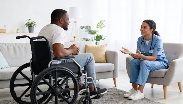 Home healthcare nurse consulting wheelchair patient in bright living room