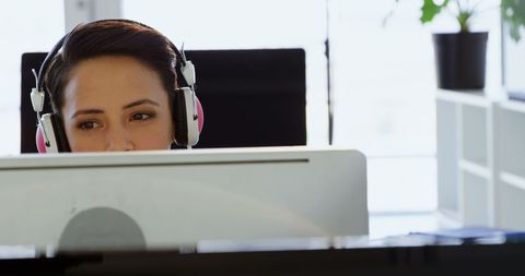 Focused Businesswoman Concentrating at Desk with Headphones - Download Free Stock Images Pikwizard.com