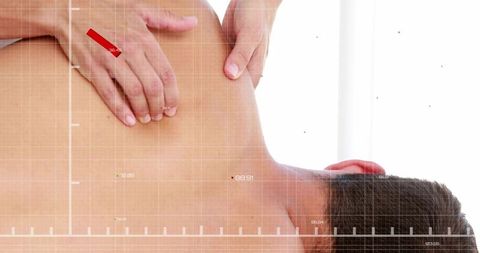 Therapist massaging male client's neck and upper back with medical diagnostic grid overlay