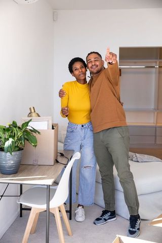 Happy couple embracing in minimalist new apartment interior