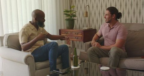 Two men engaging in relaxed conversation in cozy living room