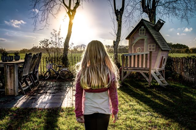 Girl Enjoying Sunset in Rustic Backyard with Playhouse - Download Free Stock Photos Pikwizard.com