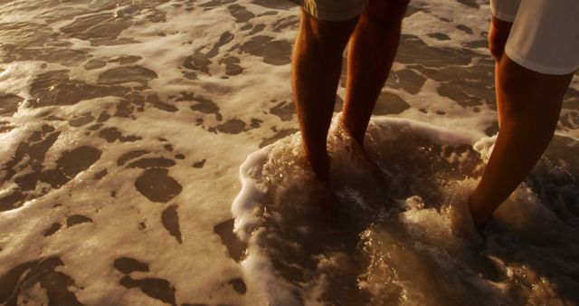 Close-up of Couple's Legs Standing in Ocean Waves at Sunset - Download Free Stock Images Pikwizard.com