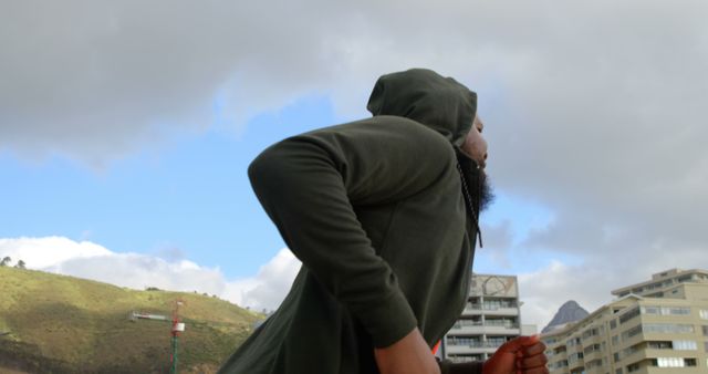 Athlete Running Outdoors with Cloudy Sky in Urban Environment - Download Free Stock Images Pikwizard.com