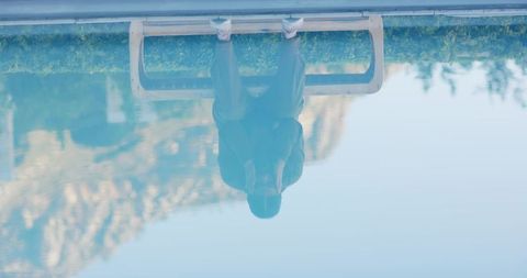 Woman Sitting on Bench Reflected in Tranquil Mountain Lake