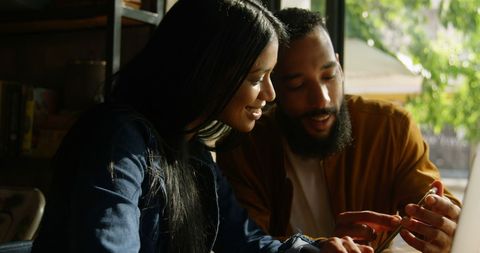 Couple Sharing Smartphone Experience in Cozy Cafe