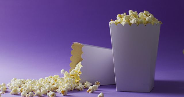 Two Popcorn Tubs on Purple Background with Spilled Popcorn - Download Free Stock Images Pikwizard.com