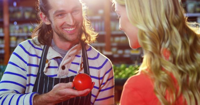 Smiling Grocer Showing Customer Fresh Tomato in Store - Download Free Stock Images Pikwizard.com