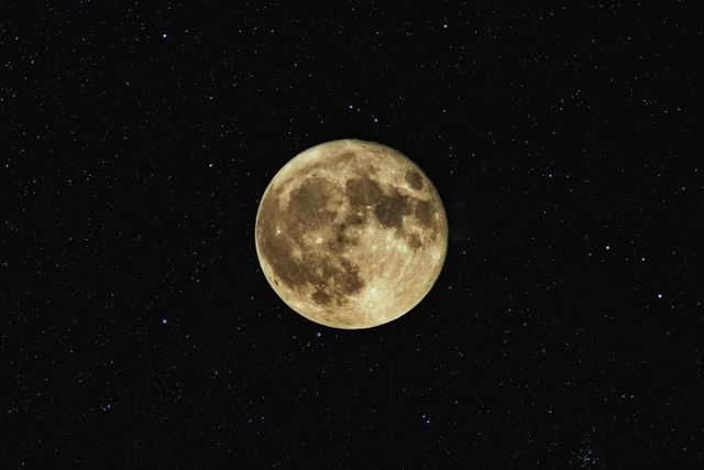 Capturing mystical full moon surrounded by twinkling stars against dark night sky. Ideal for use in themes of astronomy, space exploration, celestial events, and nighttime beauty. Suitable for travel blogs, science articles, wallpapers, and educational materials.