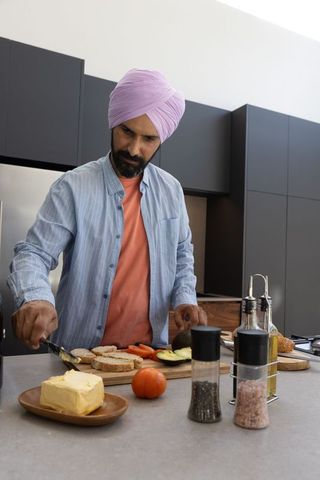 Man wearing turban preparing food in modern kitchen